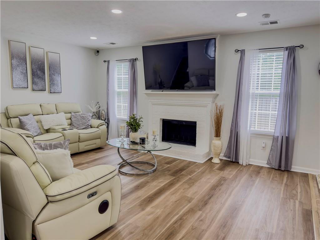 1559 Woodmore Road Southwest Marietta, GA 30008 - Photo 23 of 43 a living room with furniture a flat screen tv and a fireplace