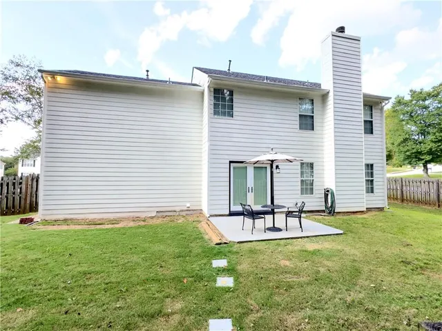 a house view with outdoor seating space and garden