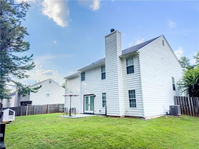 a view of a house with a yard and sitting area