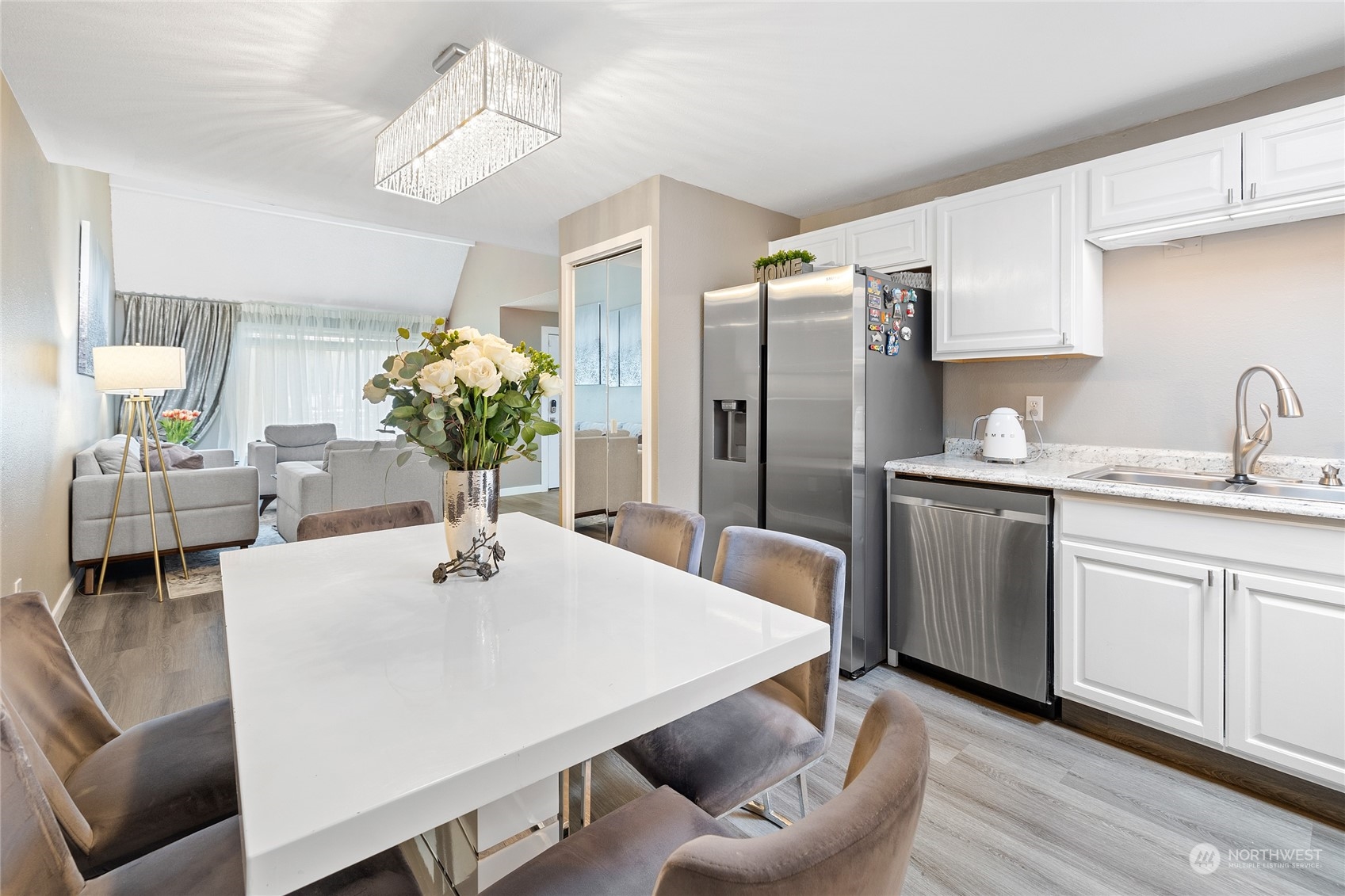 14600 Southeast 176th Street, Unit O2 Renton, WA 98058 - Photo 8 of 24 a kitchen with stainless steel appliances kitchen island granite countertop a table chairs and a refrigerator