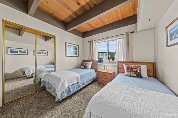 a bedroom with two beds and a large window