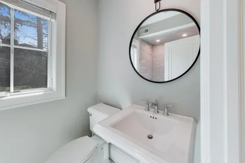 a bathroom with a sink mirror and toilet