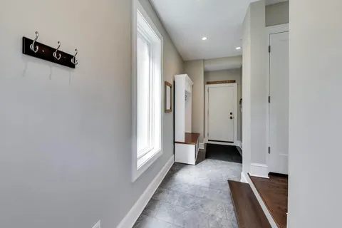 a view of a hallway with closet and a window