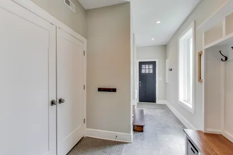 a view of a hallway with wooden floor and closet