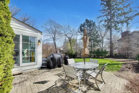 a view of a table and chairs in backyard of the house