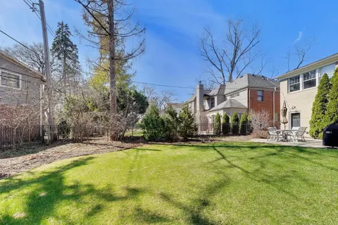a view of a house with a yard and tree s