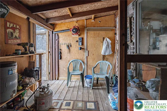 a view of a roof deck with table and chairs couches under an umbrella with wooden floor