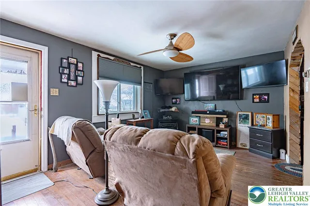a living room with furniture a flat screen tv and kitchen view