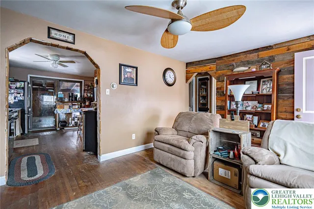 a living room with furniture ceiling fan and a rug