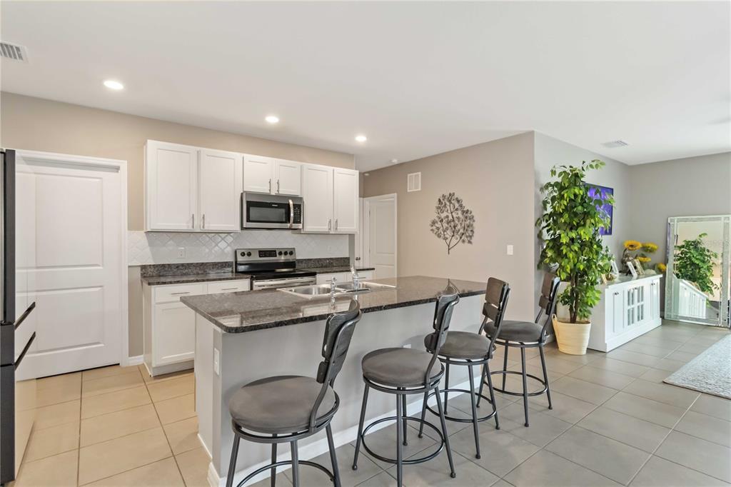 5904 Silver Sage Way Sarasota, FL 34232 - Photo 14 of 43 a kitchen with granite countertop a counter space cabinets and stainless steel appliances