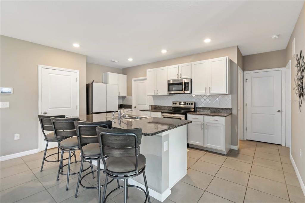 5904 Silver Sage Way Sarasota, FL 34232 - Photo 15 of 43 a kitchen with stainless steel appliances kitchen island granite countertop a sink and cabinets