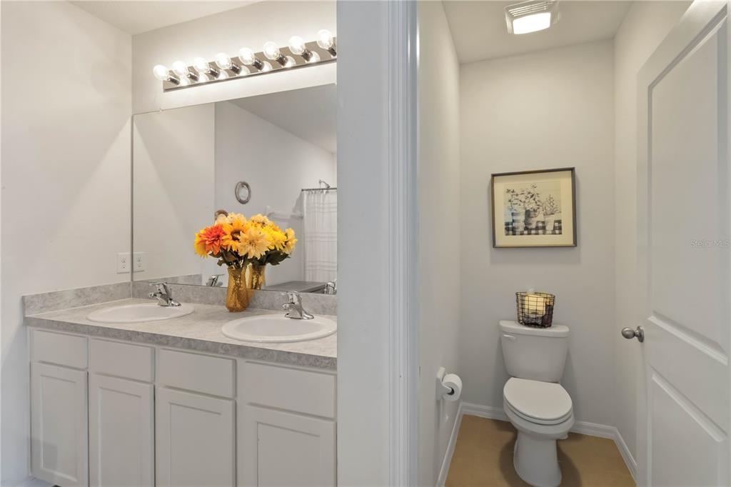 5904 Silver Sage Way Sarasota, FL 34232 - Photo 27 of 43 a bathroom with a sink a toilet and a mirror