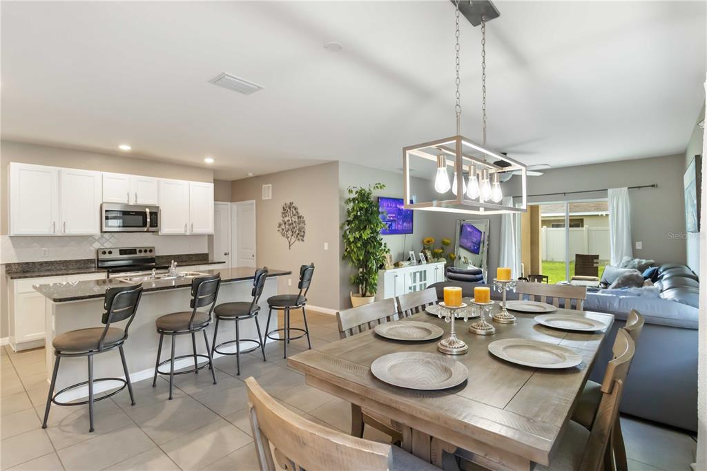 5904 Silver Sage Way Sarasota, FL 34232 - Photo 10 of 43 a dining room with furniture a chandelier and kitchen view