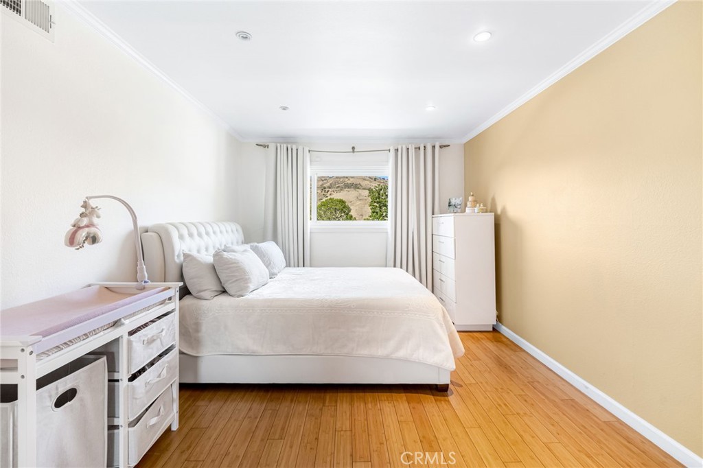 12115 Braemore Place Porter Ranch, CA 91326 - Photo 28 of 36 a bedroom with a bed and wooden floor