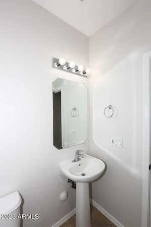 a bathroom with a sink a toilet and mirror