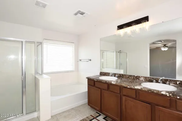 a bathroom with a granite countertop sink mirror and a bathtub