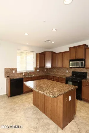 a kitchen with stainless steel appliances granite countertop a stove a sink and a refrigerator