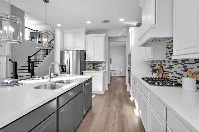 a kitchen with stainless steel appliances a sink stove and cabinets