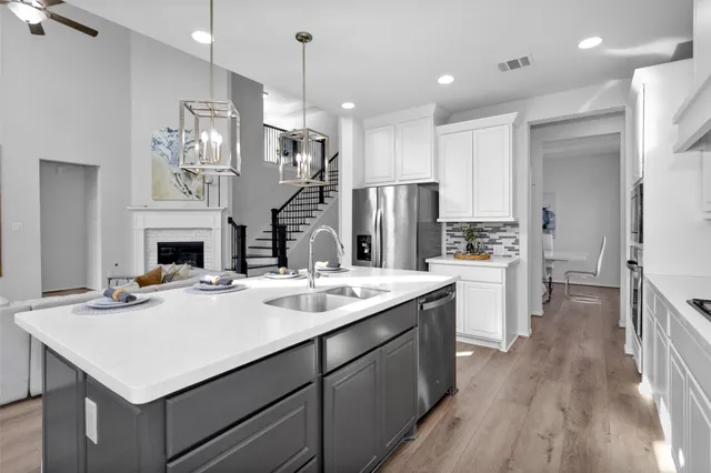 a kitchen with a sink a refrigerator and a stove top oven