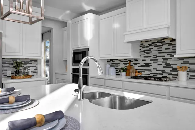 a kitchen with a sink a stove and cabinets