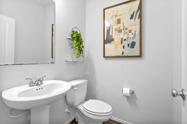 a bathroom with a toilet sink and mirror