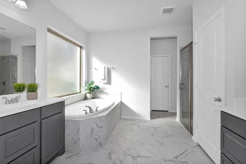 a spacious bathroom with a double vanity sink a mirror and a bathtub