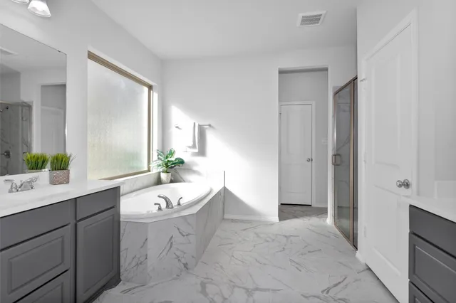 a spacious bathroom with a double vanity sink a mirror and a bathtub