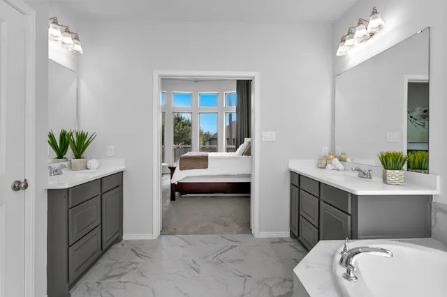 a en suite bathroom with a granite countertop sink and a mirror