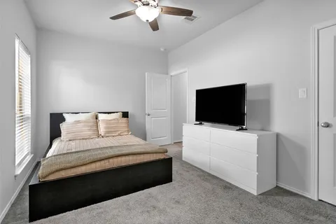 a bedroom with a bed and a flat screen tv