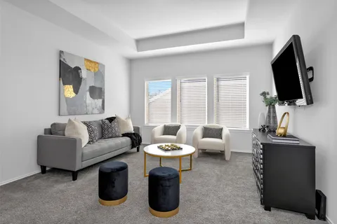 a living room with furniture a flat screen tv and a large window