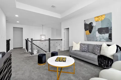 a living room with furniture and a view of kitchen