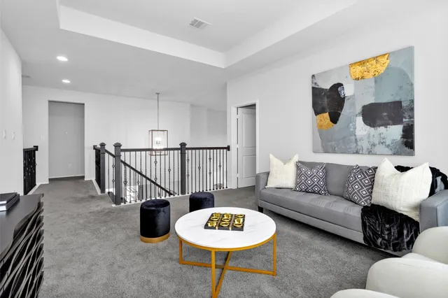 a living room with furniture and a view of kitchen