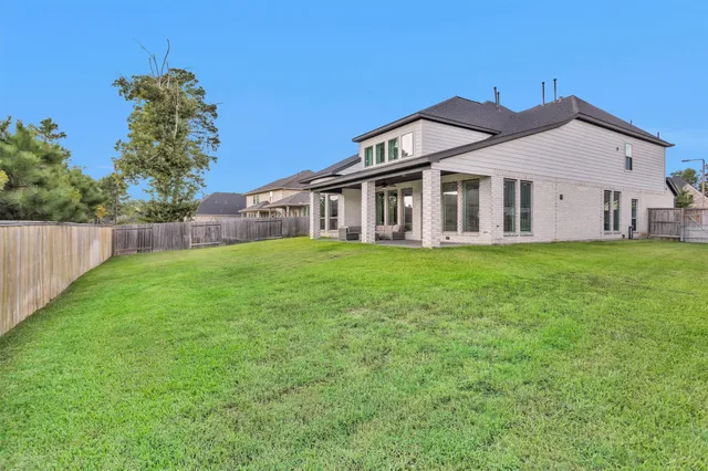 a big white house with a yard and wooden fence