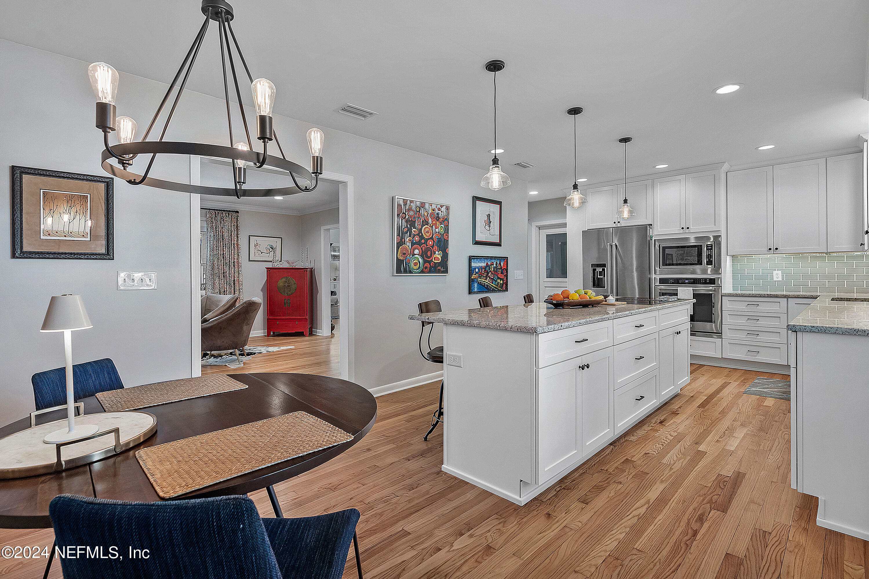 4724 Devon Lane Jacksonville, FL 32210 - Photo 9 of 40 a kitchen view with stainless steel appliances kitchen island granite countertop a table chairs and a wooden floor