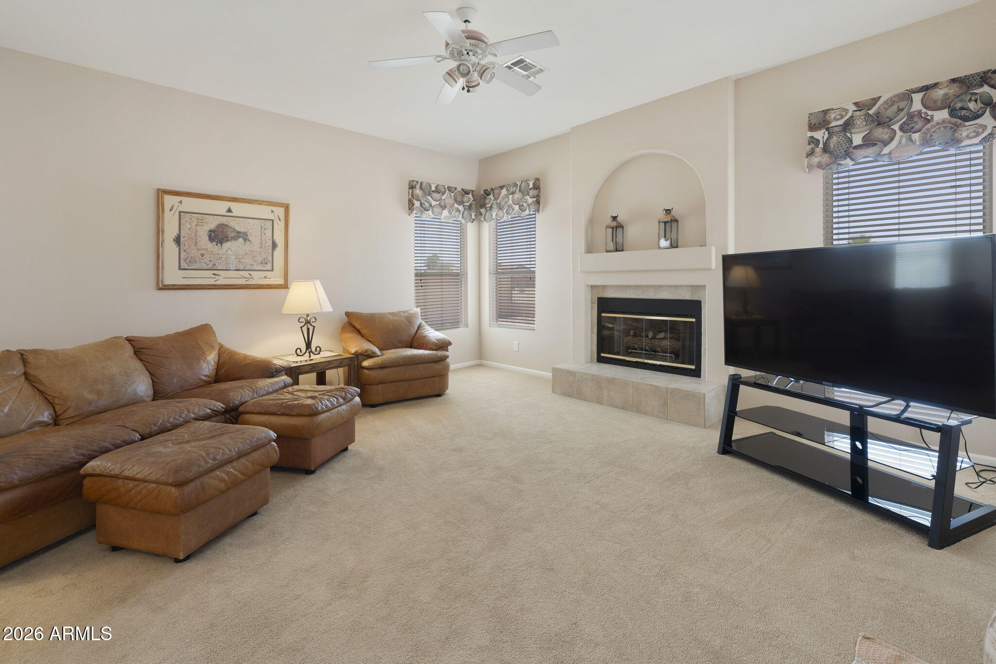 12435 West Monte Vista Road Avondale, AZ 85392 - Photo 26 of 69 a living room with furniture a fireplace and a flat screen tv