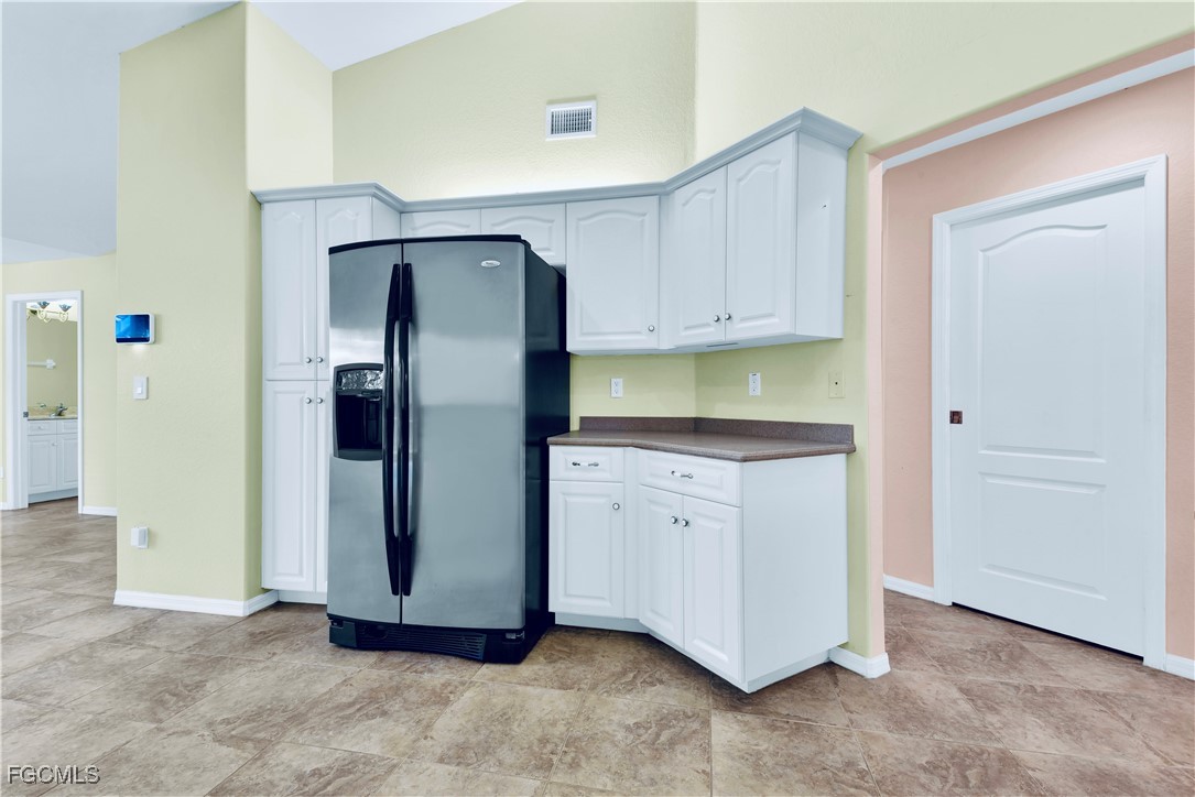 909 Magnolia Avenue Lehigh Acres, FL 33972 - Photo 19 of 38 a kitchen with stainless steel appliances granite countertop a refrigerator and a stove