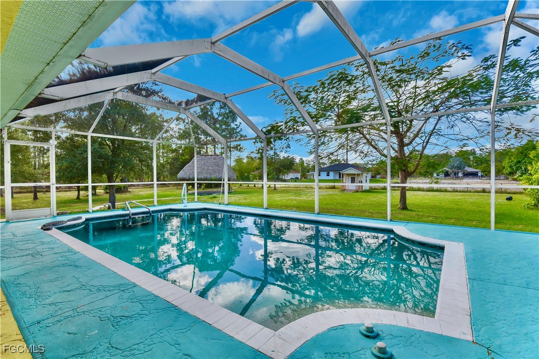 909 Magnolia Avenue Lehigh Acres, FL 33972 - Photo 2 of 38 a view of a backyard with swimming pool