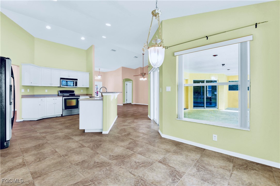 909 Magnolia Avenue Lehigh Acres, FL 33972 - Photo 22 of 38 a view of a kitchen with furniture and stainless steel appliances