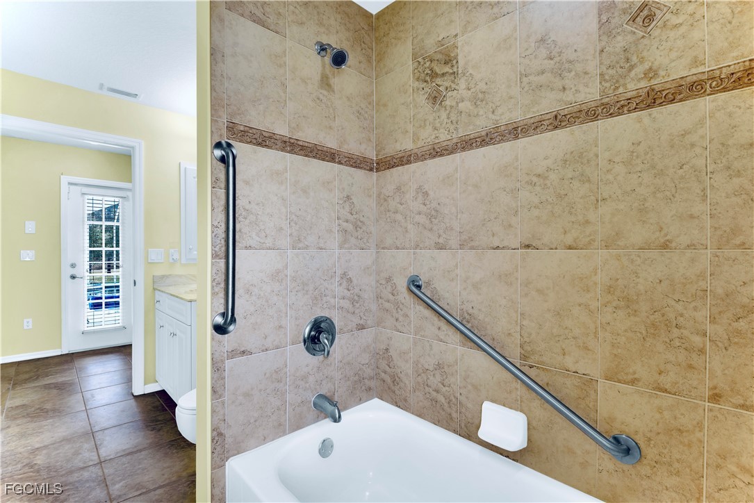 909 Magnolia Avenue Lehigh Acres, FL 33972 - Photo 28 of 38 a bathroom with a bathtub and shower