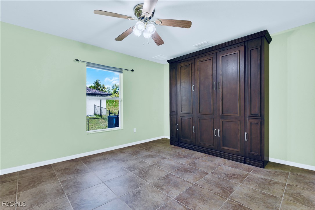 909 Magnolia Avenue Lehigh Acres, FL 33972 - Photo 29 of 38 an empty room with windows and fan