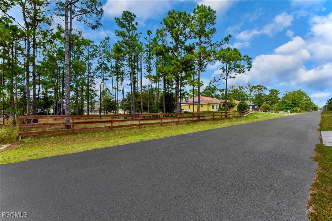 909 Magnolia Avenue Lehigh Acres, FL 33972 - Photo 34 of 38 a view of a swimming pool with an outdoor space and seating area