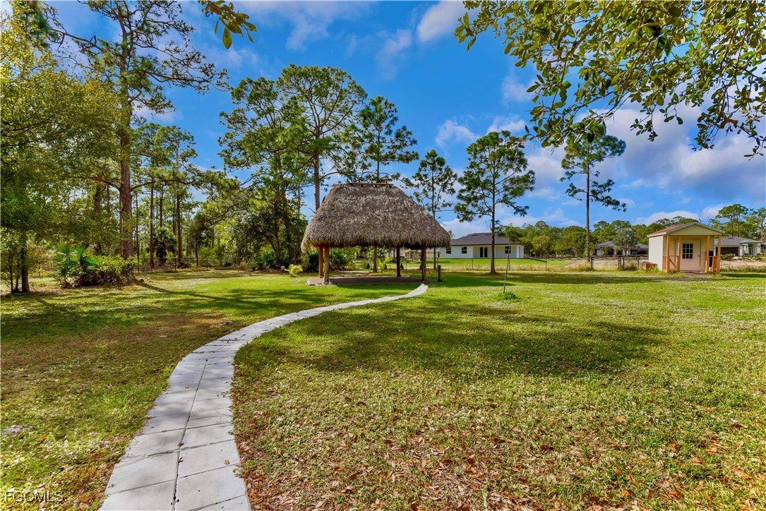909 Magnolia Avenue Lehigh Acres, FL 33972 - Photo 6 of 38 a view of a garden with a building in the background