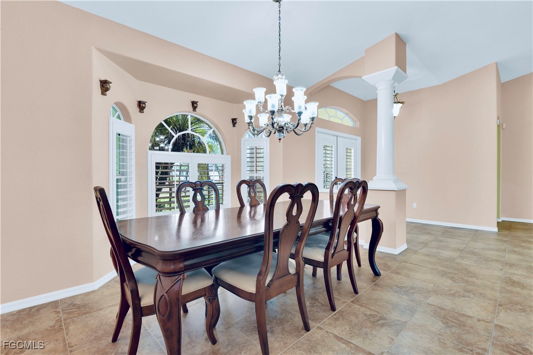909 Magnolia Avenue Lehigh Acres, FL 33972 - Photo 10 of 38 a view of a dining room with furniture a chandelier and wooden floor