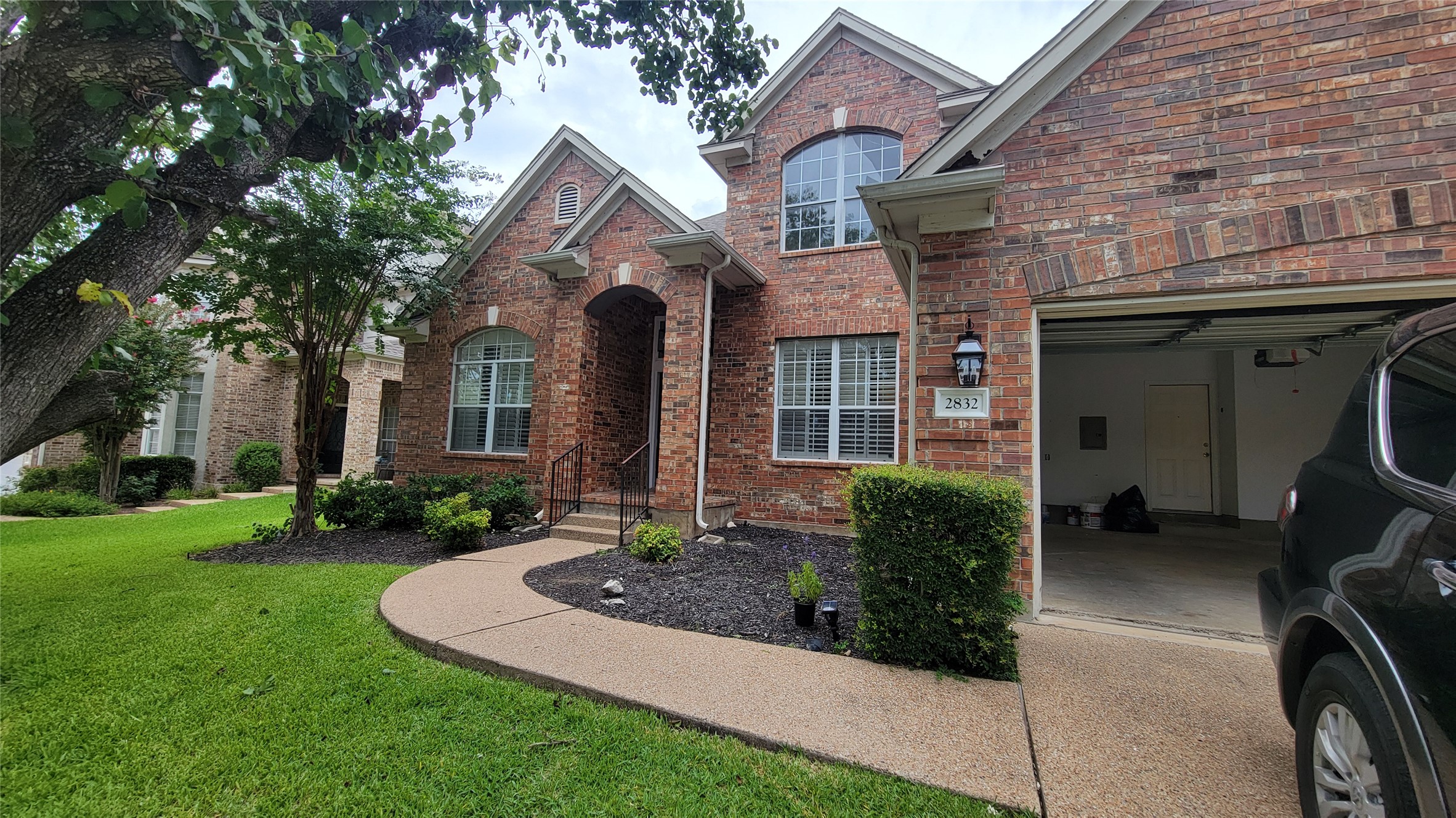 2832 Grimes Ranch Road Austin, TX 78732 - Photo 2 of 37 A classic brick exterior offers curb appeal with a well-maintained lawn and arched entry.
