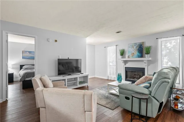 a living room with furniture a fireplace and a flat screen tv