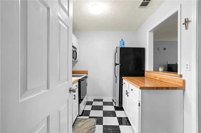 a kitchen with a refrigerator and a stove top oven