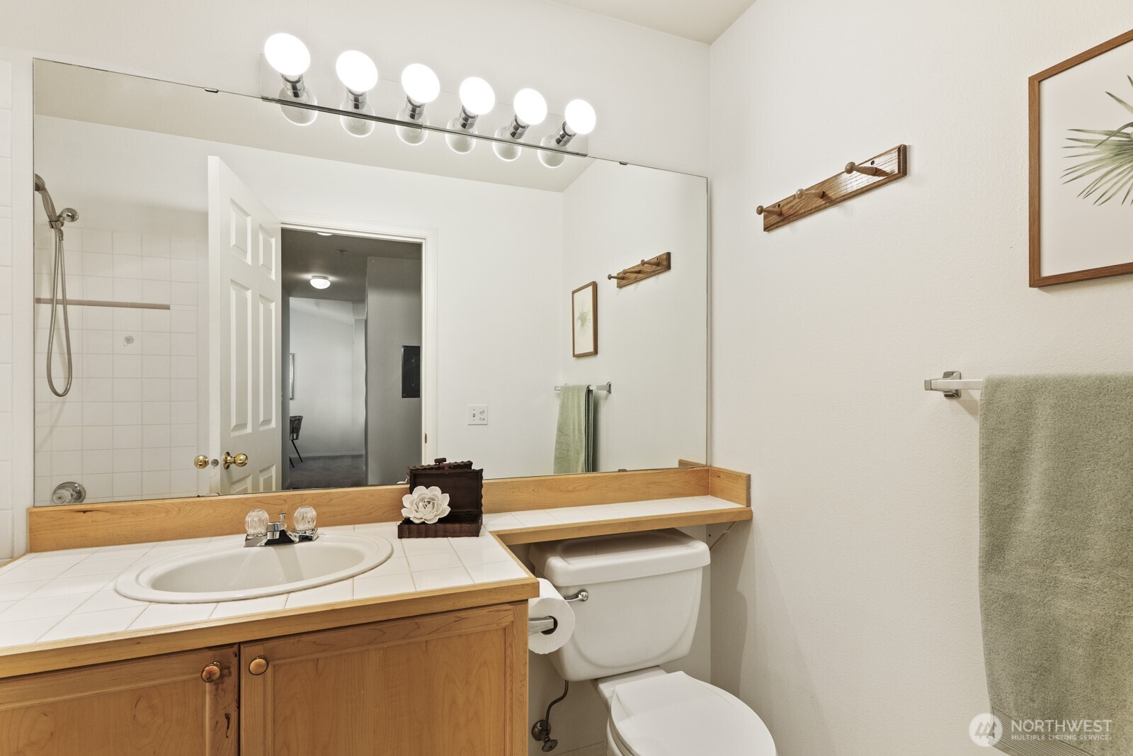 17204 123rd Place Northeast, Unit N304 Bothell, WA 98011 - Photo 32 of 40 a bathroom with a sink a toilet a mirror and shower