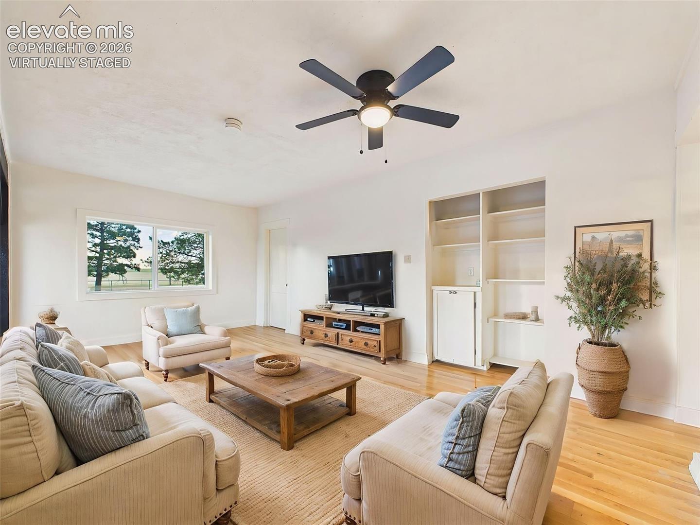 23015 Murphy Road Calhan, CO 80808 - Photo 15 of 50 (Virtually Staged) Living Area – Open gathering space features beautiful flooring, updated lighting, and architectural beam details that add warmth and character.
