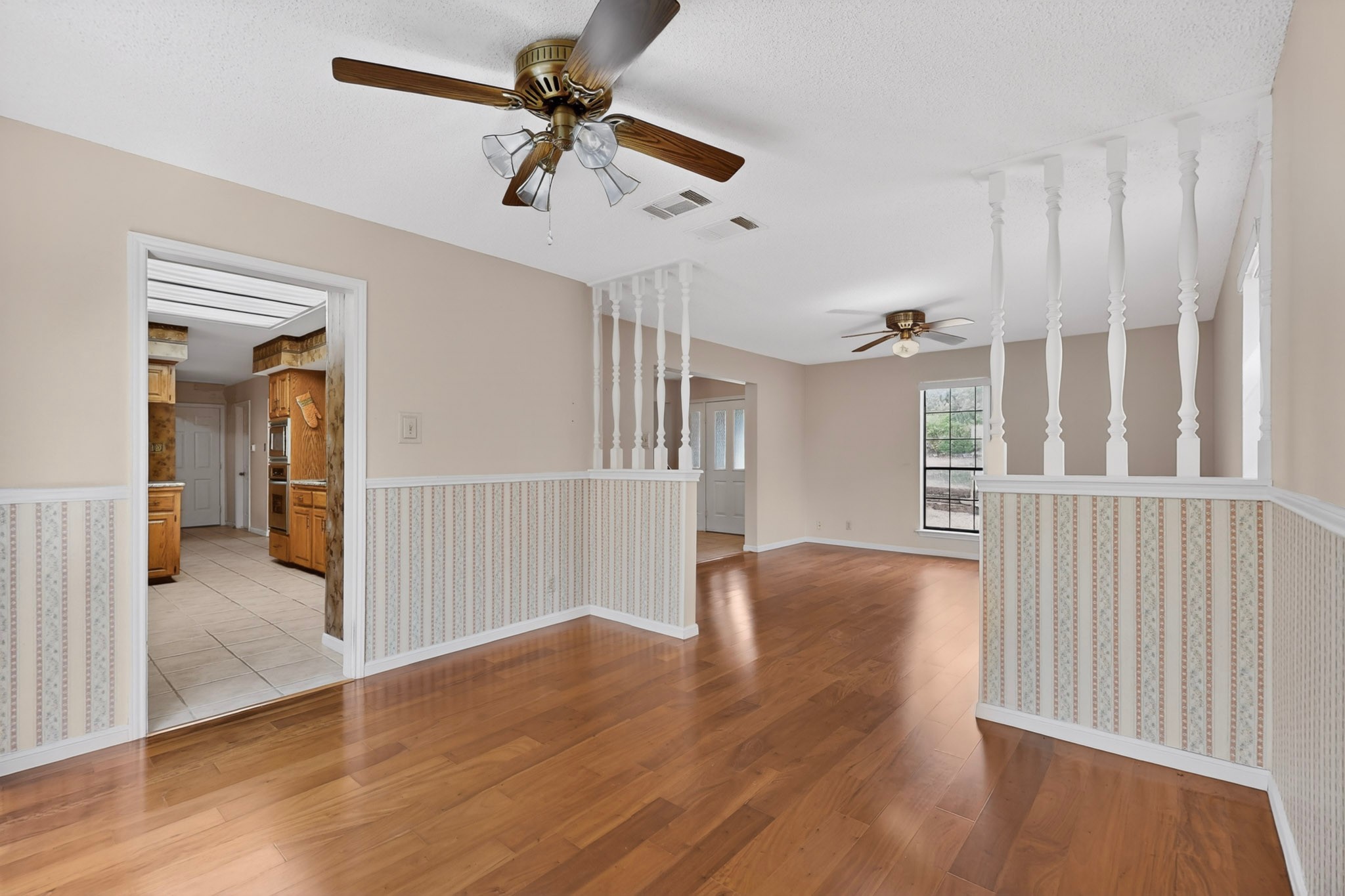 1003 Pier Branch Road Dripping Springs, TX 78620 - Photo 18 of 40 Rich hardwood flooring extends through this generously sized living area, illuminated by a window overlooking mature trees.