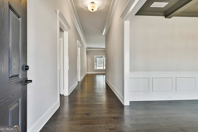 a view of a hallway with wooden floor and staircase